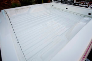 View of the clean truck bed painted in the same white as the body