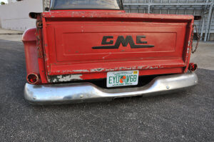 Scratched paint on the rear exterior and dinged chrome bumpers of the custom 1958 GMC 100.