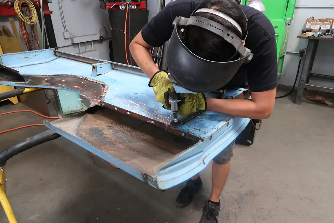 Using a series of sanding discs, Kyle grinds down the welds