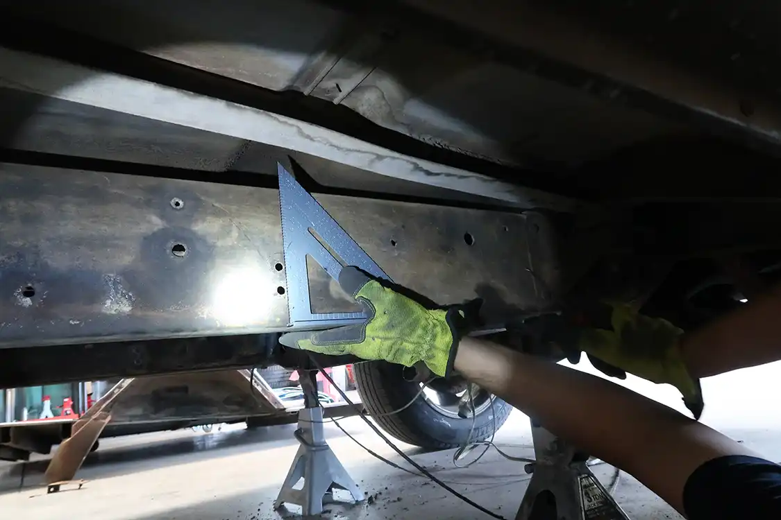 Kyle marks a spot on the frame where he can remove 12 inches